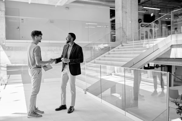 Två män som skakar hand i en modern kontorsmiljö